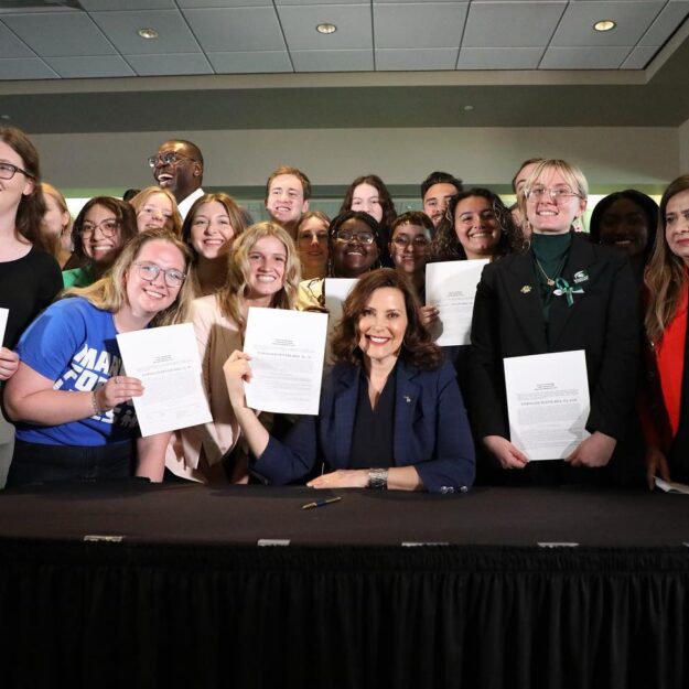 March For Our Lives activists gather around Gov. Whitmer as she signs historic gun safety into law.